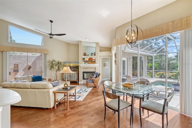 dining space with light hardwood / wood-style floors, vaulted ceiling, and a wealth of natural light