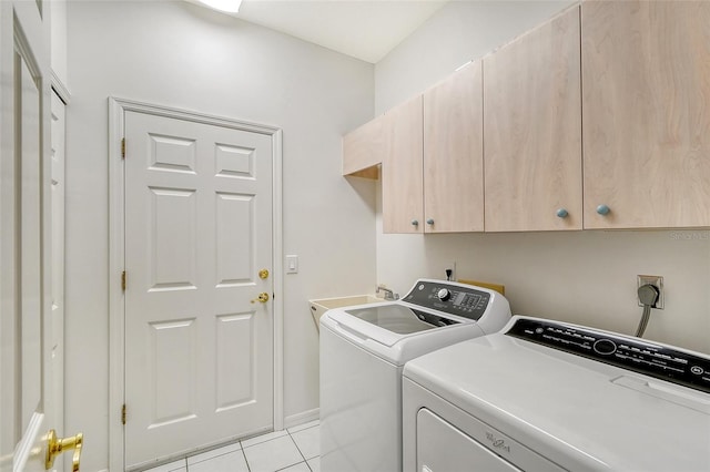 laundry room featuring light tile patterned flooring, cabinets, and separate washer and dryer