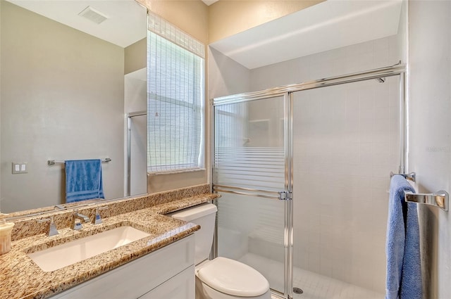 bathroom featuring walk in shower, vanity, and toilet