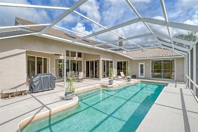 view of pool with a lanai, grilling area, and a patio