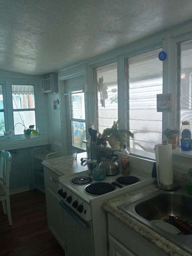 kitchen featuring a textured ceiling, plenty of natural light, white electric range oven, and dark hardwood / wood-style floors