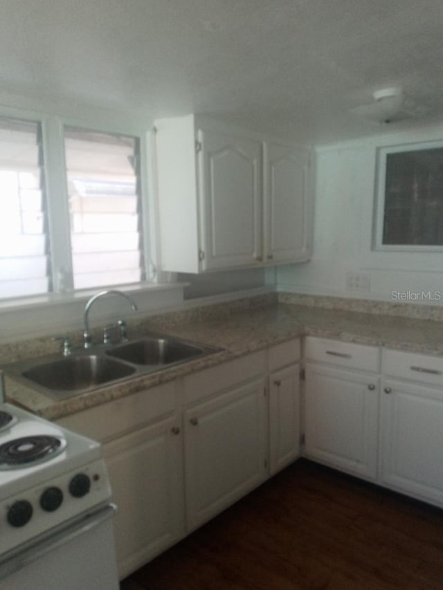 kitchen featuring white range with electric stovetop, dark hardwood / wood-style flooring, white cabinets, and sink