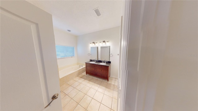 bathroom featuring tile patterned floors, vanity, a bathtub, and a textured ceiling