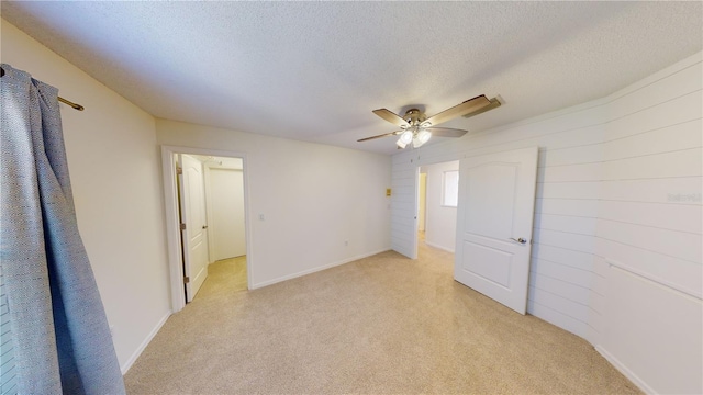 carpeted spare room with ceiling fan and a textured ceiling