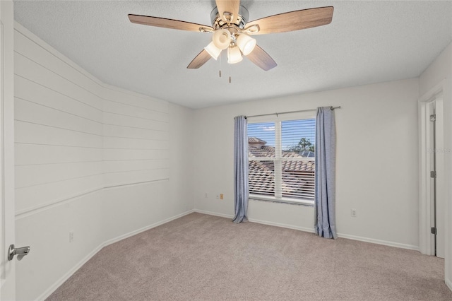 carpeted empty room with ceiling fan and a textured ceiling