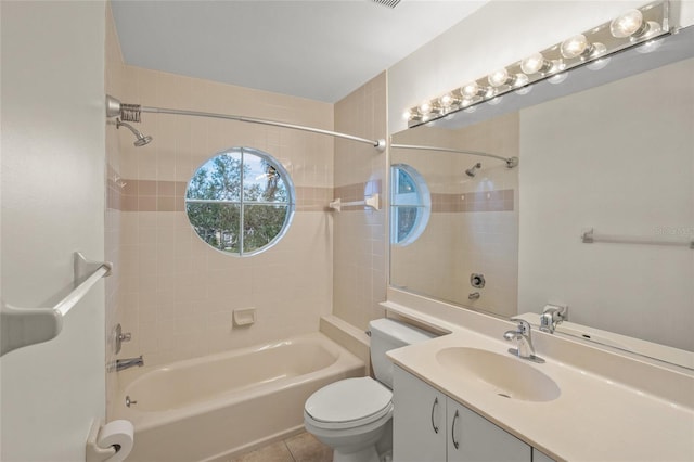 full bathroom with tiled shower / bath, tile patterned flooring, vanity, and toilet