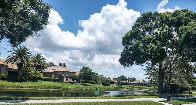 surrounding community featuring a water view and a lawn