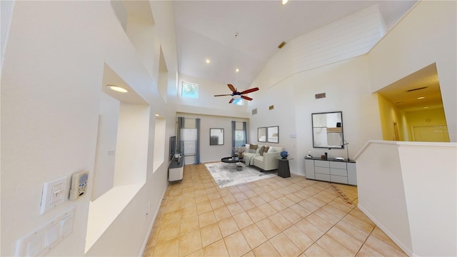 living room featuring high vaulted ceiling, ceiling fan, and light tile patterned flooring