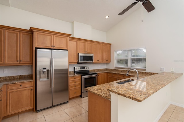 kitchen with kitchen peninsula, light stone countertops, stainless steel appliances, ceiling fan, and sink