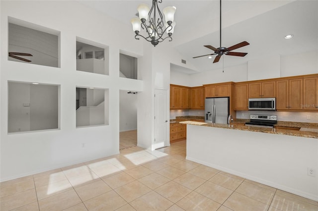 kitchen featuring light stone counters, light tile patterned floors, pendant lighting, and appliances with stainless steel finishes