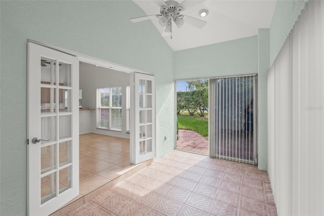 interior space featuring a wealth of natural light, ceiling fan, light tile patterned floors, and lofted ceiling