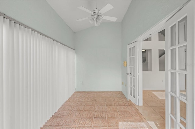 tiled empty room featuring french doors, ceiling fan, and lofted ceiling