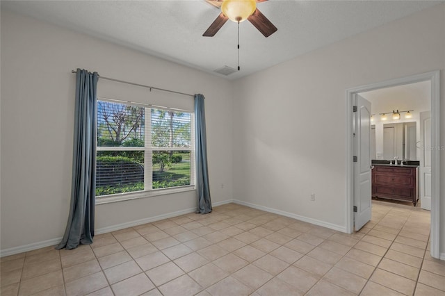 spare room with ceiling fan, sink, light tile patterned floors, and a textured ceiling