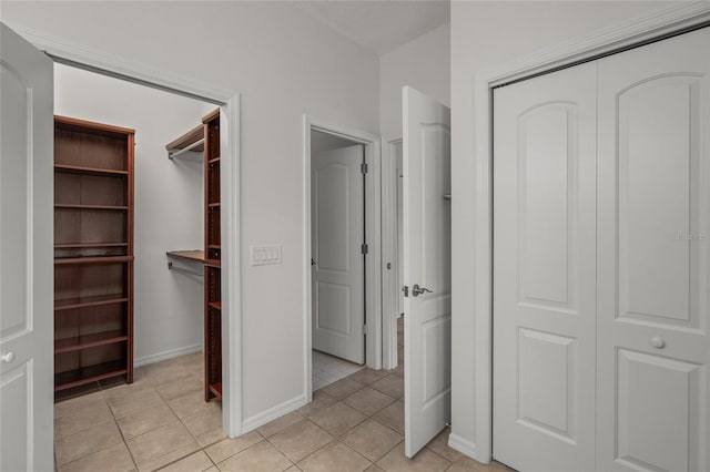 unfurnished bedroom featuring light tile patterned floors and a closet