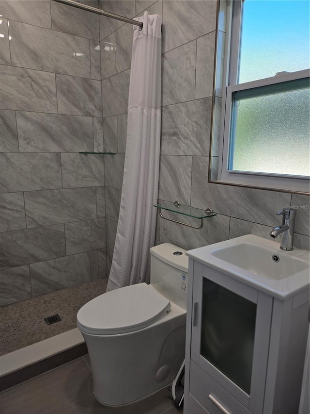 bathroom featuring a shower with curtain, vanity, toilet, and tile walls