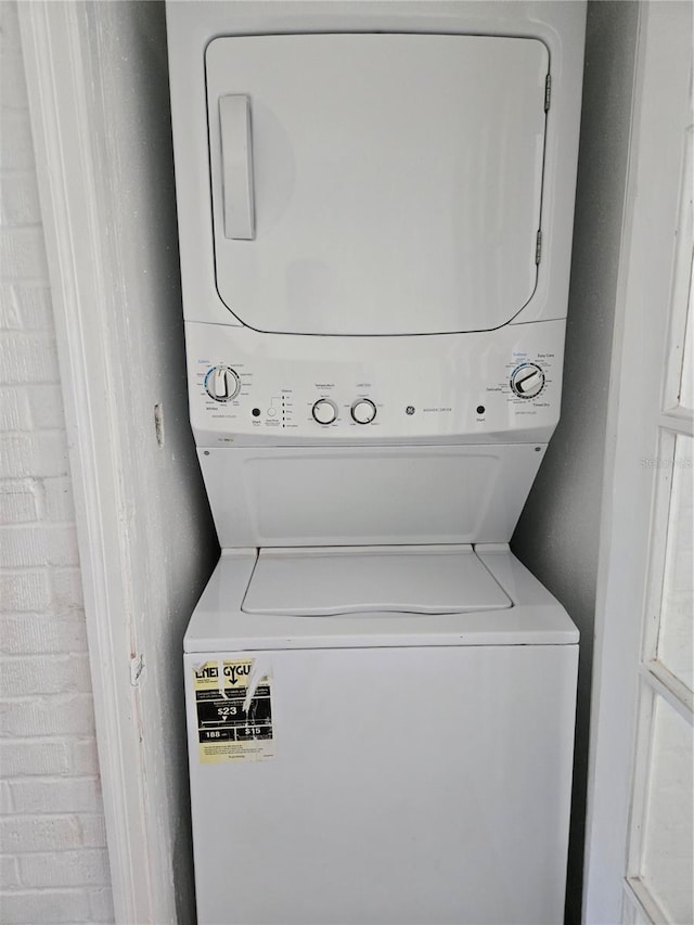 clothes washing area with stacked washer / dryer