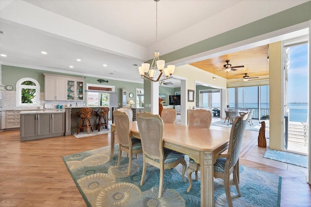 dining room with ceiling fan with notable chandelier, light hardwood / wood-style floors, and ornamental molding