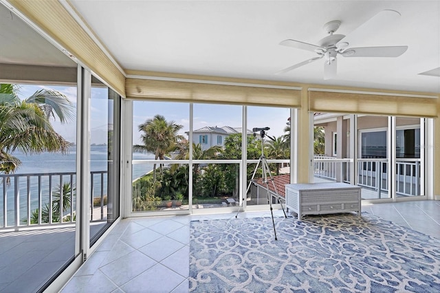 unfurnished sunroom featuring a water view, a wealth of natural light, and ceiling fan