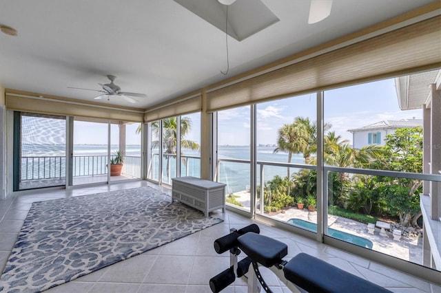 sunroom / solarium with a water view and ceiling fan