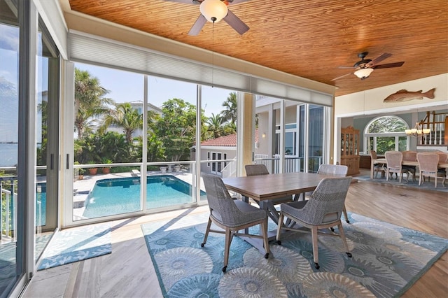 sunroom featuring wooden ceiling and ceiling fan with notable chandelier