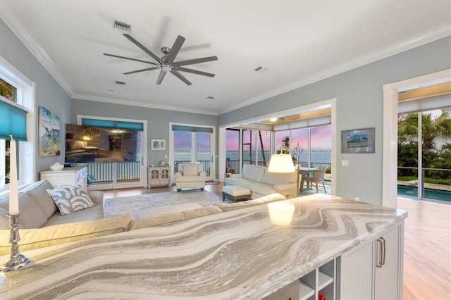 living room with light hardwood / wood-style floors, plenty of natural light, crown molding, and ceiling fan