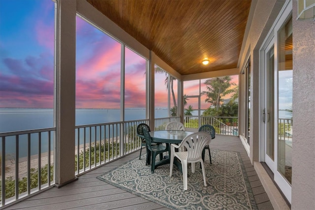 sunroom featuring a water view and wooden ceiling