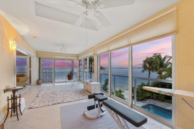 sunroom / solarium with a water view and ceiling fan