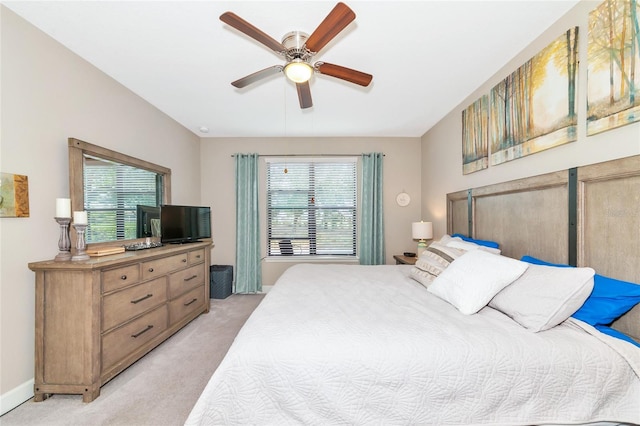 bedroom with ceiling fan, light carpet, and multiple windows