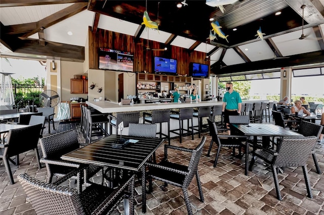 dining room with beamed ceiling, ceiling fan, and high vaulted ceiling