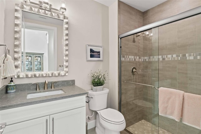 bathroom featuring toilet, an enclosed shower, and vanity