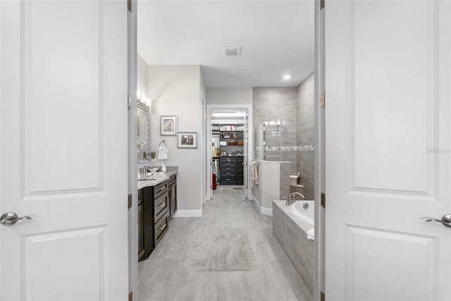 bathroom featuring vanity and independent shower and bath