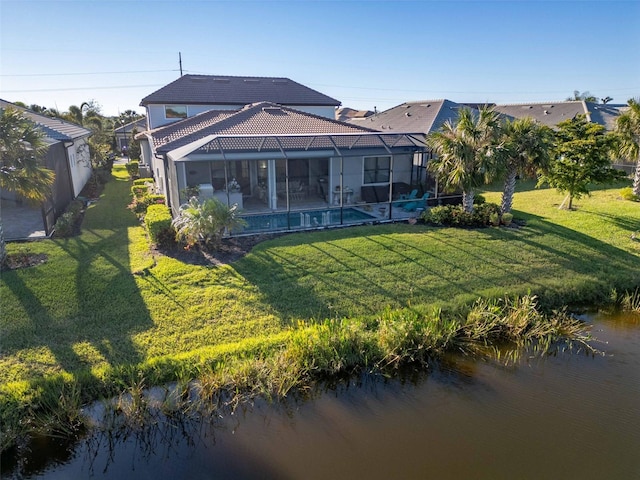 back of house with a lanai, a yard, and a water view