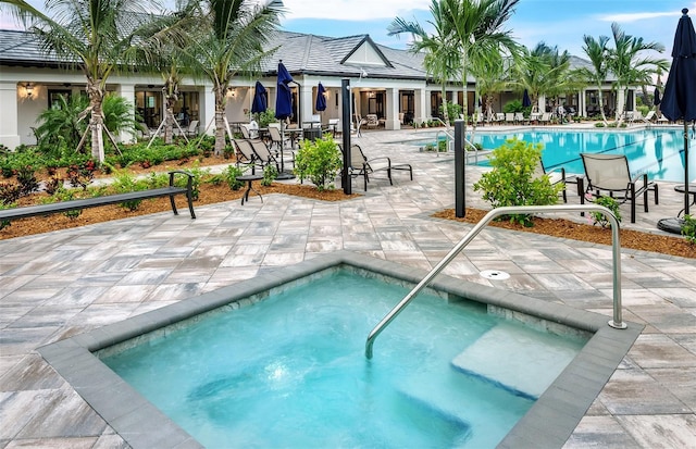 view of swimming pool with a patio area and a community hot tub