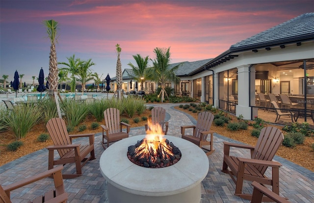 patio terrace at dusk featuring a fire pit