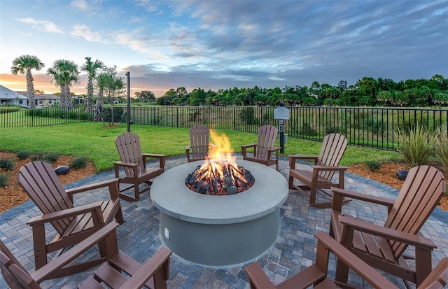 patio terrace at dusk with a fire pit and a yard