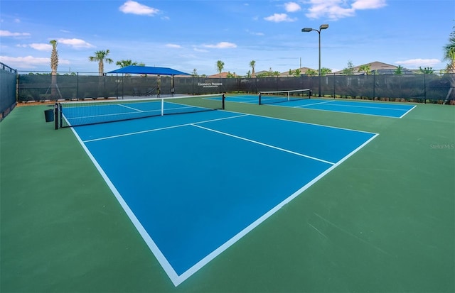 view of tennis court with basketball hoop