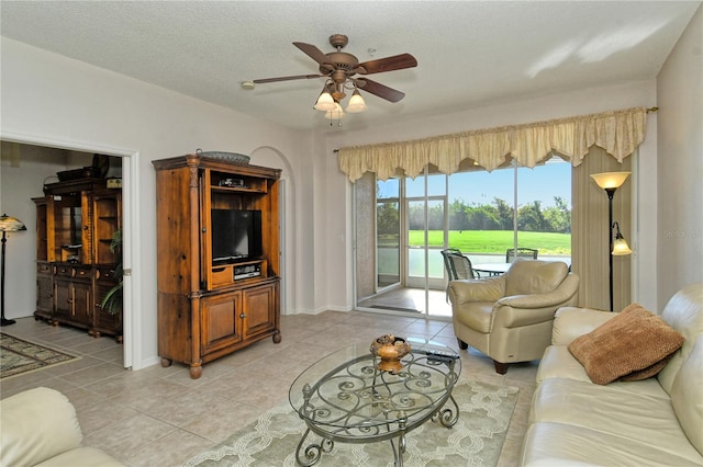 tiled living room featuring ceiling fan and a textured ceiling