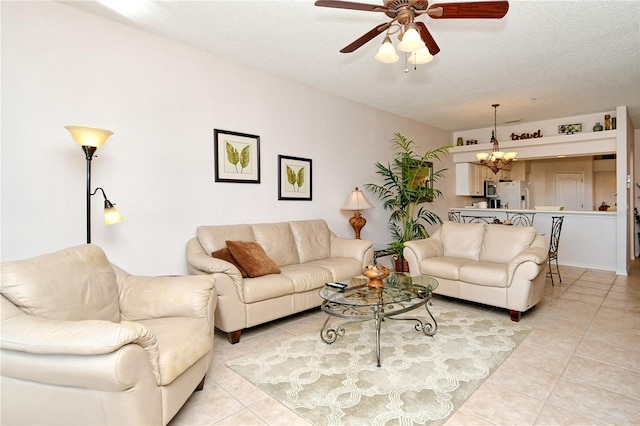 living room featuring ceiling fan with notable chandelier, light tile patterned floors, and a textured ceiling