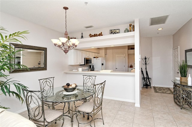 dining space featuring light tile patterned floors, a textured ceiling, and an inviting chandelier