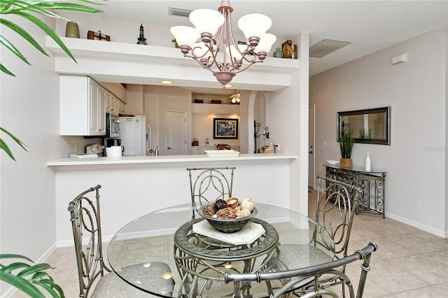 tiled dining room with a chandelier