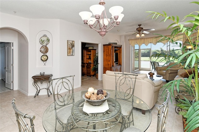 tiled dining space featuring a textured ceiling and ceiling fan with notable chandelier