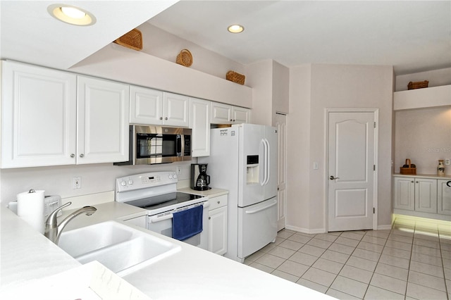 kitchen featuring white cabinets, light tile patterned floors, white appliances, and sink