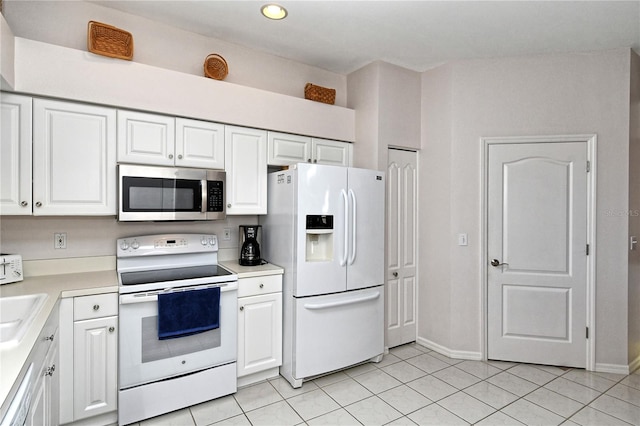 kitchen featuring appliances with stainless steel finishes, sink, white cabinetry, and light tile patterned flooring