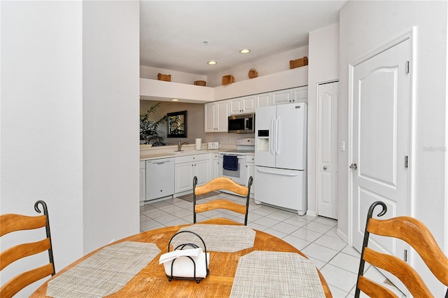 kitchen featuring white cabinetry, sink, light tile patterned floors, and white appliances