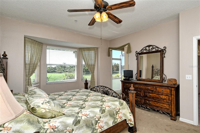 carpeted bedroom with multiple windows, a textured ceiling, and ceiling fan