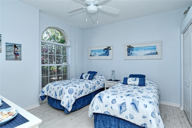 bedroom featuring a closet, light hardwood / wood-style floors, and ceiling fan