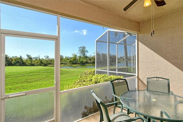 sunroom / solarium featuring a water view, a wealth of natural light, and ceiling fan