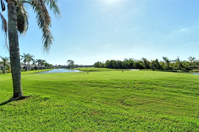 view of property's community with a yard and a water view