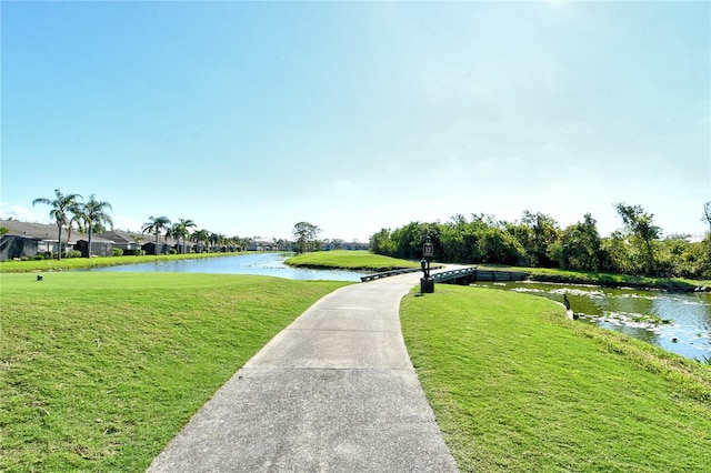 view of community featuring a water view and a yard