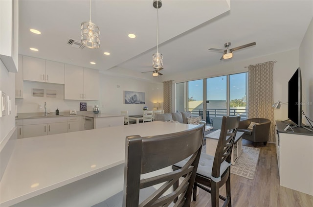 kitchen featuring pendant lighting, sink, ceiling fan, light hardwood / wood-style floors, and white cabinetry